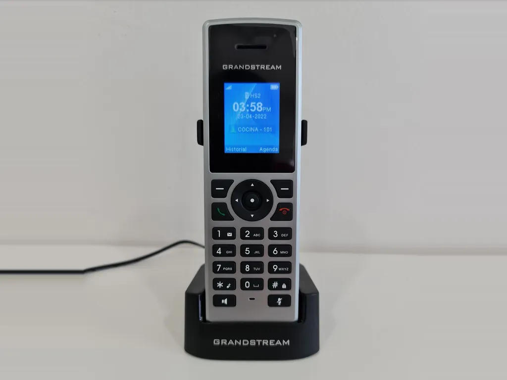 Teléfono inalámbrico IP en su base de carga, mostrando la extensión 101 en pantalla
